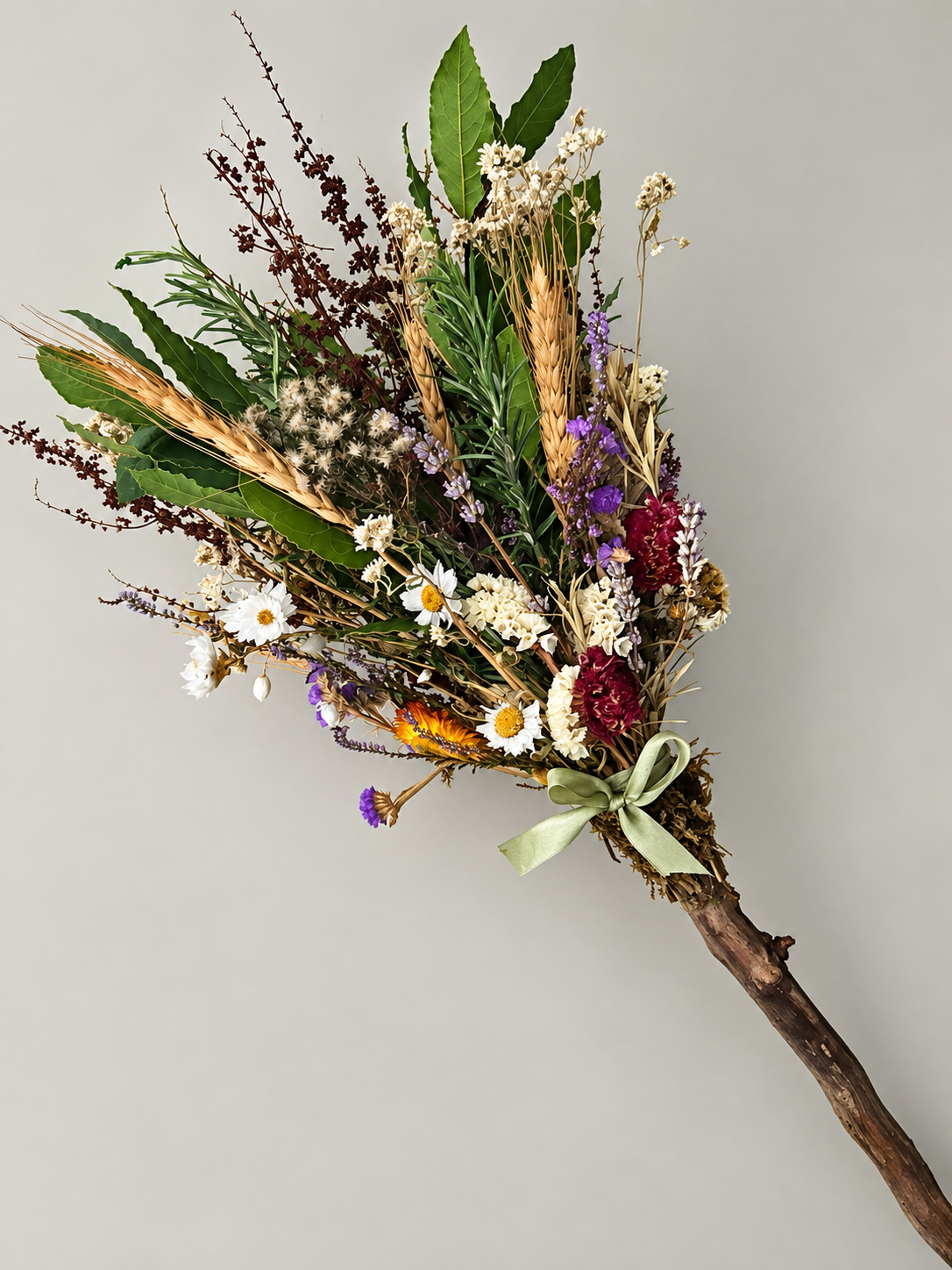 Halloween broomstick decorated with dried autumn leaves, grasses and flowers